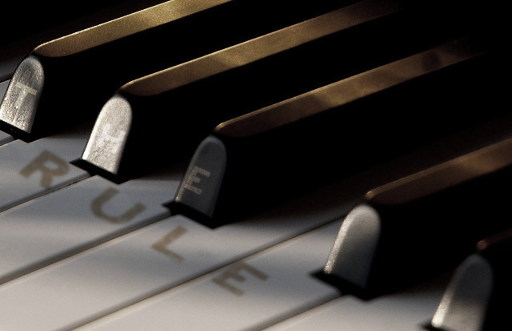 Photo of a piano, with The Rule written on it